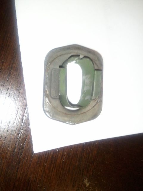 1994 Ford Bronco - Close-up of a metal bracket with a green interior, likely a vehicle part.
