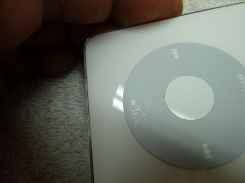 2007 Subaru Impreza - A close-up view of a white electronic device with a circular control pad, showing wear and tear.