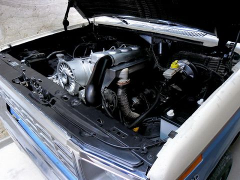 1983 Ford F-100 - The engine bay shows a modified setup with a prominent turbocharger and custom intake plumbing.