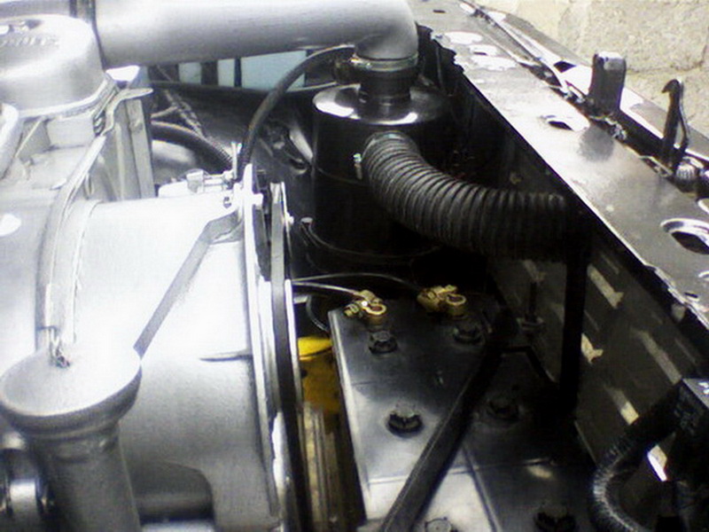 Engine bay with air intake hose, battery terminals, and part of the engine block visible