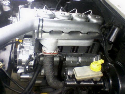 1983 Ford F-100 - Close-up view of an engine compartment, showing the intake manifold and brake fluid reservoir.