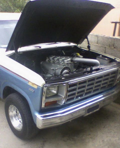 1983 Ford F-100 - Front view of a 1983 Ford F-100 pickup truck with the hood open, revealing the engine.