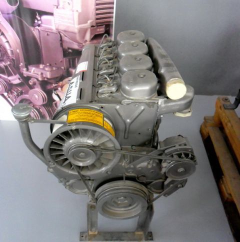1983 Ford F-100 - Engine displayed on a stand, a fan, belts, and a prominent yellow warning label with text.