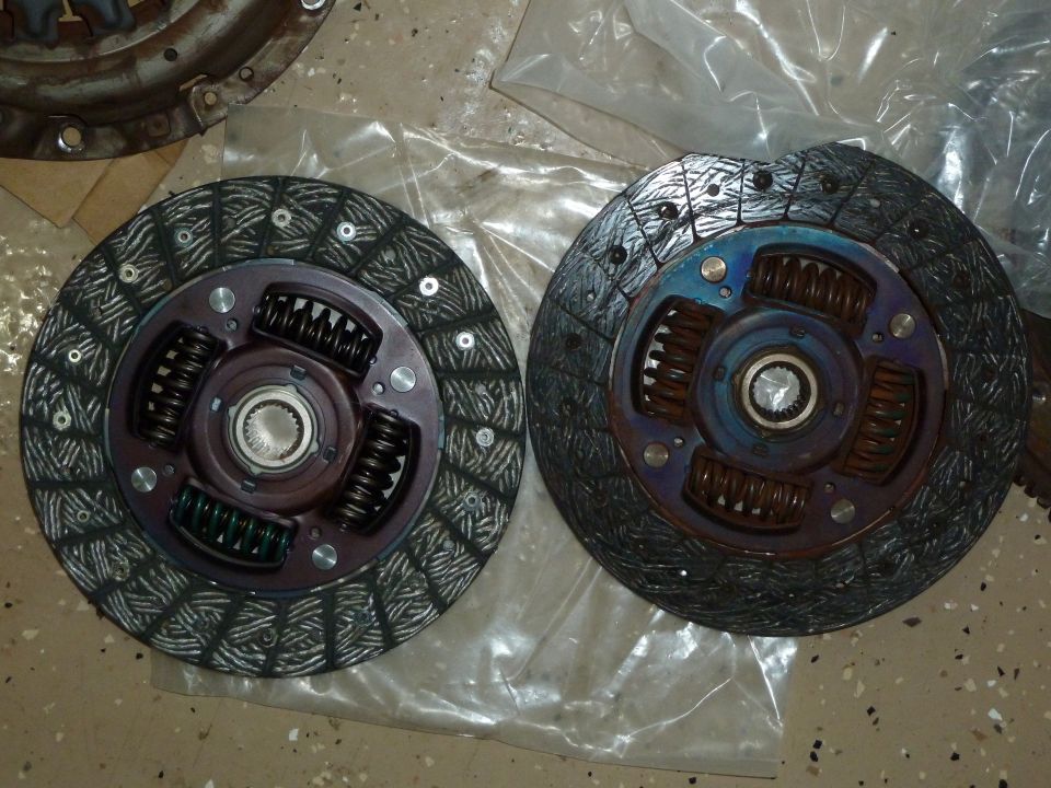 Two clutch discs, one new and one worn, with visible springs and splined hubs