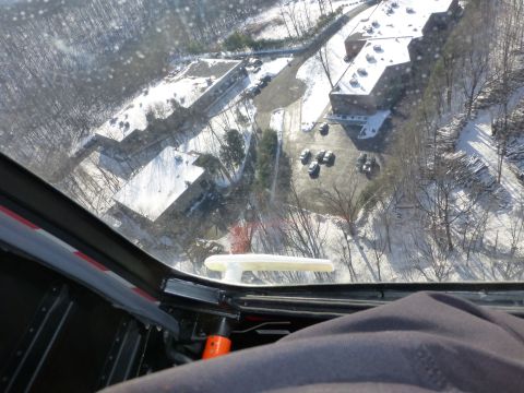 1959 Kenworth W900A - An aerial perspective shows buildings and cars dusted with snow, viewed from inside a vehicle.