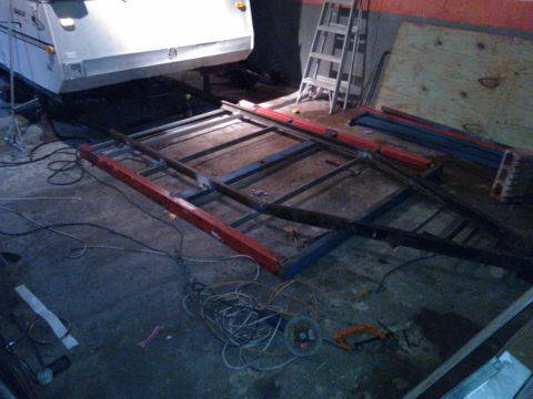 1984 Ford Bronco - Metal frame construction for a trailer is underway, with various tools and materials scattered around the workshop floor.