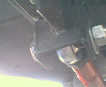 1984 Ford Bronco - Close-up of a vehicle's suspension system, showing mechanical components and a red shock absorber.