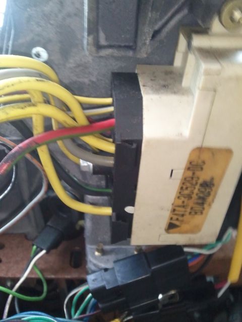 1994 Ford Bronco - Detail of electrical components and wiring within a vehicle's interior, showing connectors and a label.