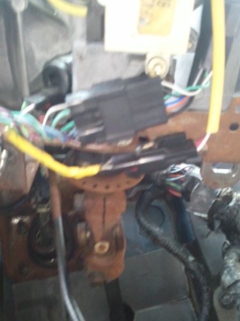 1994 Ford Bronco - Close-up view of the wiring harness and steering column components within a vehicle's interior.