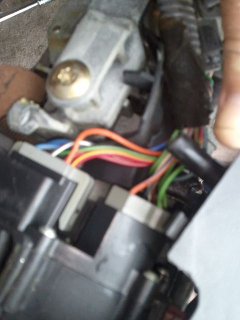 1994 Ford Bronco - A close-up view of a vehicle's interior wiring harness, showing various colored wires connected to electrical components.