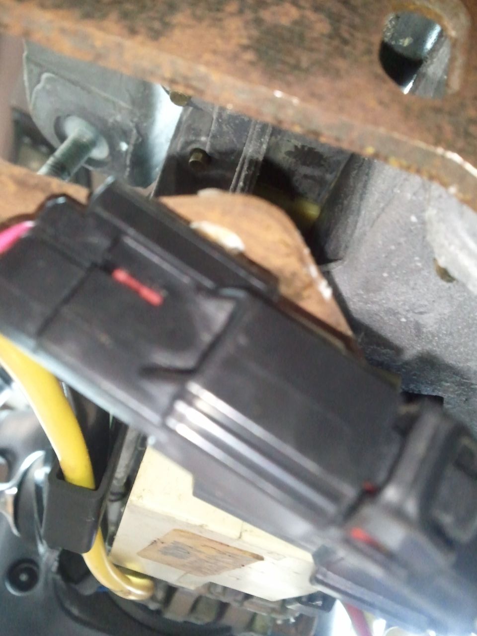 close-up of a black electrical connector with yellow wire and red stripe