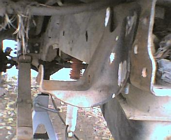 1984 Ford Bronco - Close-up view of a vehicle's undercarriage, focusing on suspension and frame components.
