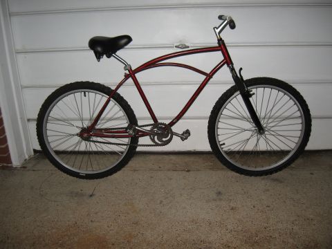 1994 Ford Bronco - A red cruiser bicycle is shown from the side, parked in front of a garage door.