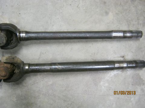 1970 Ford Bronco - Two axle shafts are shown on a concrete floor, with a date stamp and website logo in the lower right corner.