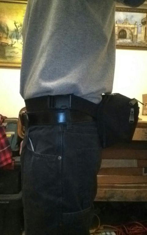 1993 Ford Bronco - A person is shown from the waist down, wearing a tool belt and dark pants.