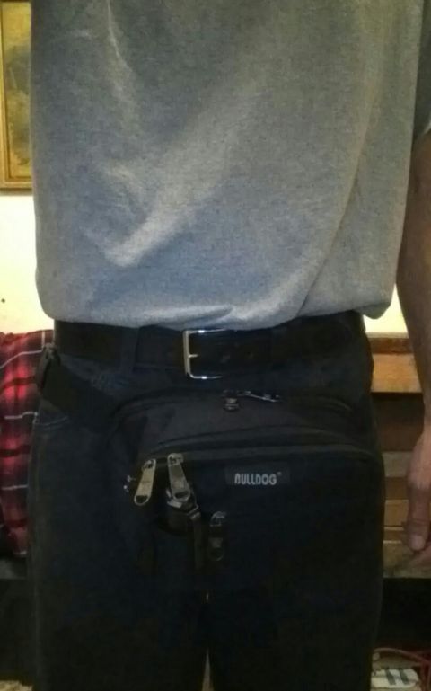 1993 Ford Bronco - A black fanny pack with zippers and a logo is worn around the waist.