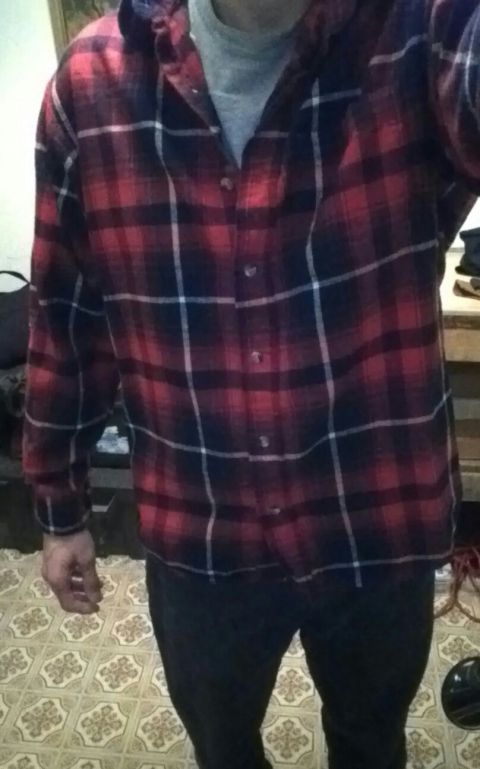 1993 Ford Bronco - Person wearing a red and black plaid shirt and dark pants indoors.