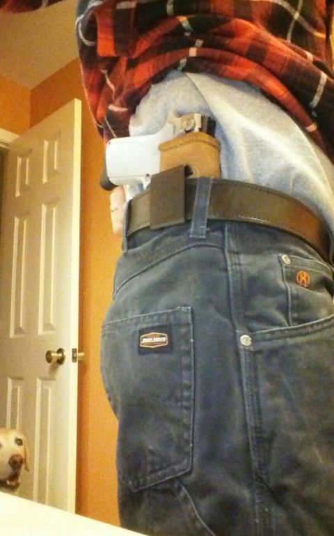 1993 Ford Bronco - A person's hip area is visible, with a handgun concealed in a holster and dark wash jeans.
