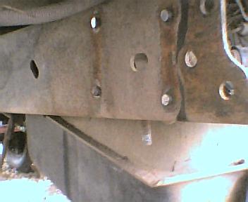 1984 Ford Bronco - This photo shows a close-up view of a vehicle's frame and suspension components, with visible rust and bolts.