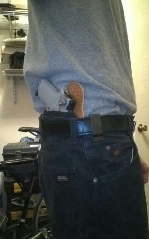 1993 Ford Bronco - A handgun with a wooden grip is concealed in a holster at the wearer's hip.