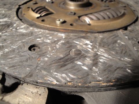 1992 Ford Taurus - Close-up of a heavily worn clutch disc, showing significant scoring and damage to the friction material.
