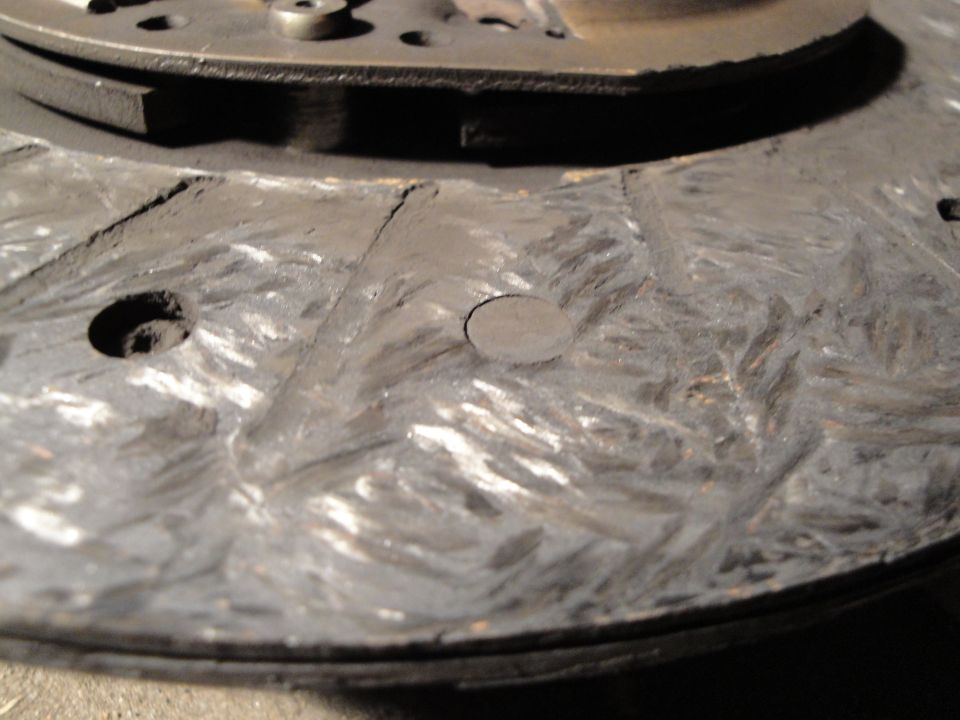 Close-up of a worn clutch disc with visible scoring and dust