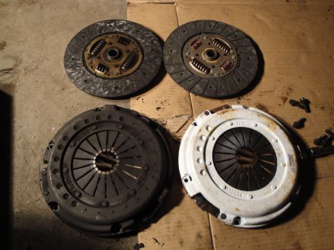 1992 Ford Taurus - Four automotive clutch components are laid out on a textured surface, showing wear and tear.