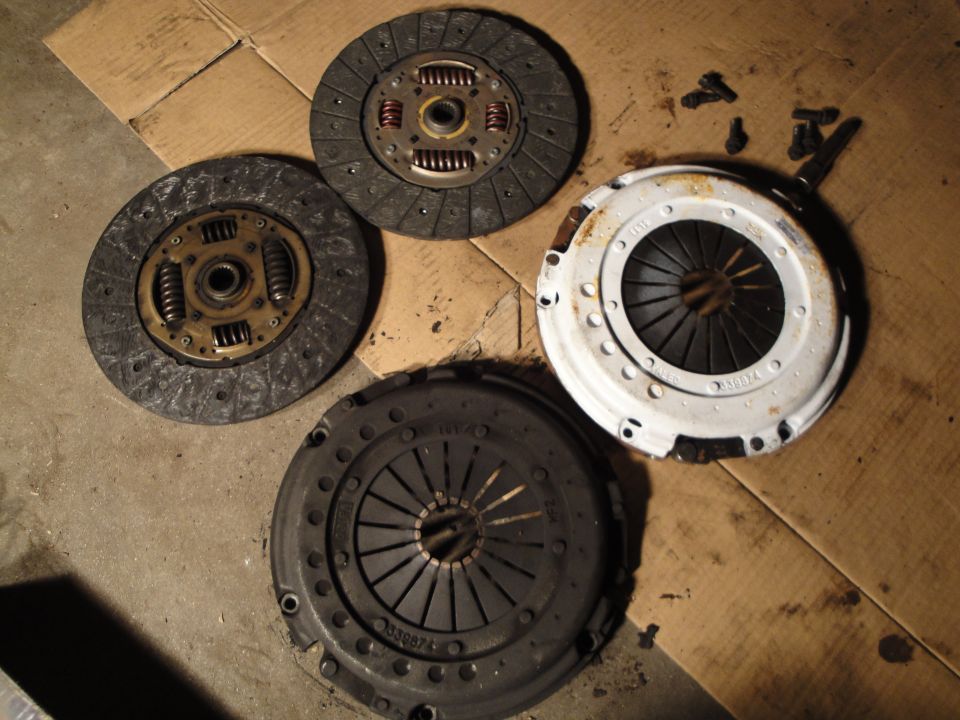 Four clutch assemblies and bolts on a cardboard surface