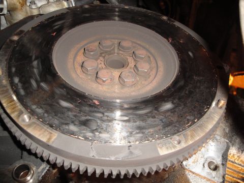 1992 Ford Taurus - Close-up view of a worn clutch flywheel, showing the gear teeth and mounting bolts.