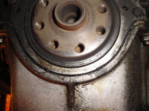 1992 Ford Taurus - A close-up view of a greasy clutch assembly, showing a metal flywheel and bolts.