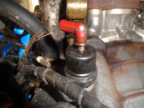 1992 Ford Taurus - Close-up of an engine component, possibly a spark plug or sensor, with a red boot and exposed wires.