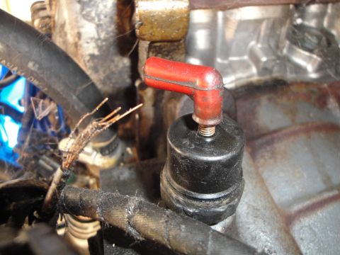 1992 Ford Taurus - A close-up view of an engine sensor with a red cap and exposed wiring, likely a component of the clutch system.