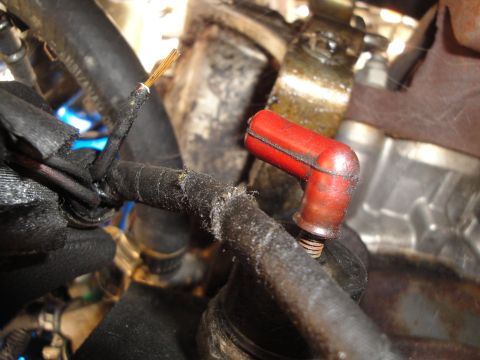 1992 Ford Taurus - Damaged spark plug wire and boot assembly on an engine.