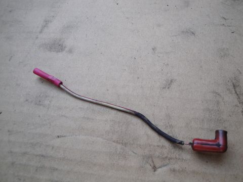 1992 Ford Taurus - A single spark plug wire with a red boot and a pink connector lies on a textured surface.
