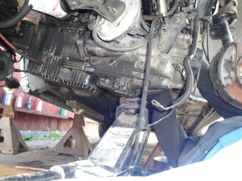 1992 Ford Taurus - Underside view of a vehicle's transmission and oil pan, showing signs of wear and tear.