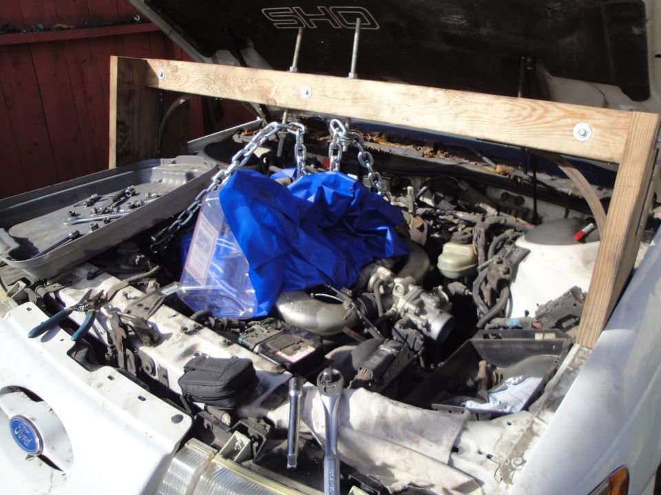 1992 Ford Taurus SHO engine bay with hoist and tools