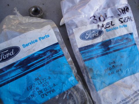 1992 Ford Taurus - Ford service parts packages with a nut. One package is labeled '3.0L SHO AXEL SEAL'.