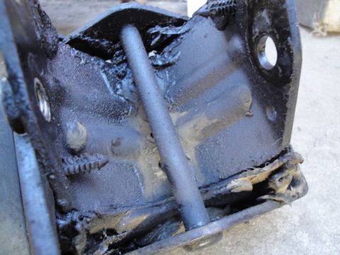 1992 Ford Taurus - Close-up of a damaged engine mount bracket, showing wear and tear on the rubber components.
