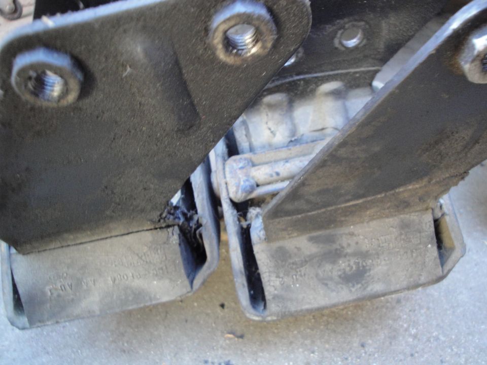 Close-up of two worn engine mounts with visible text