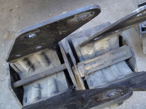 1992 Ford Taurus - Close-up view of several worn and cracked rubber engine mounts, likely needing replacement.