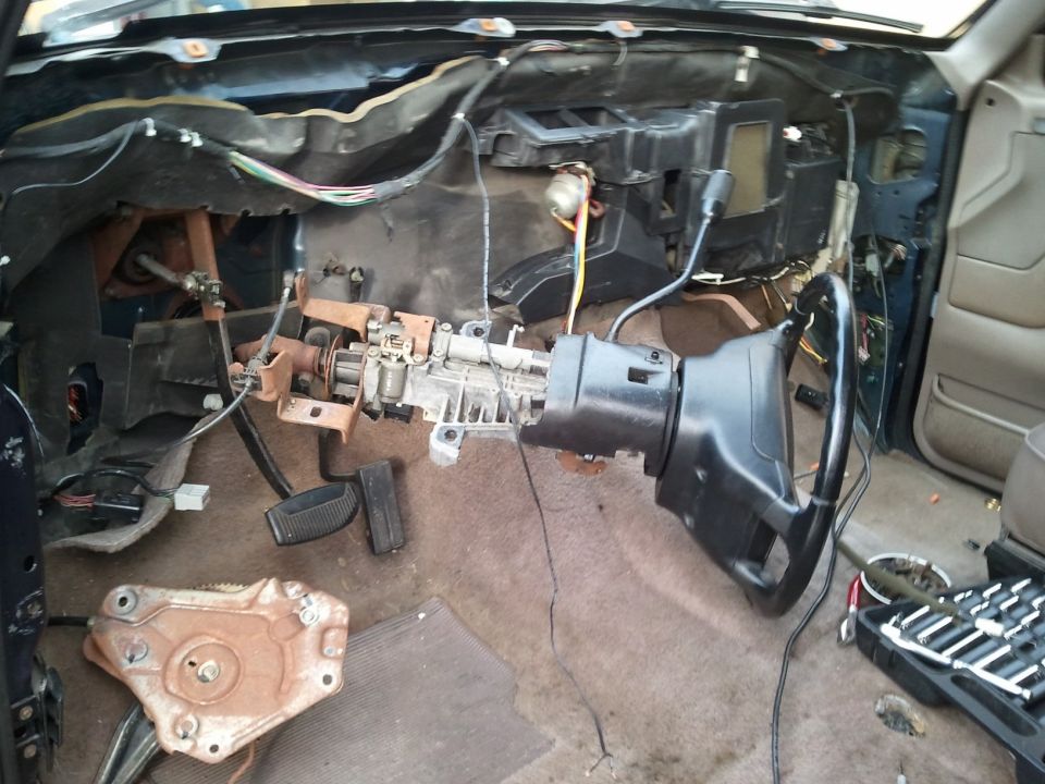 1994 Ford Bronco interior with disassembled dashboard and steering column