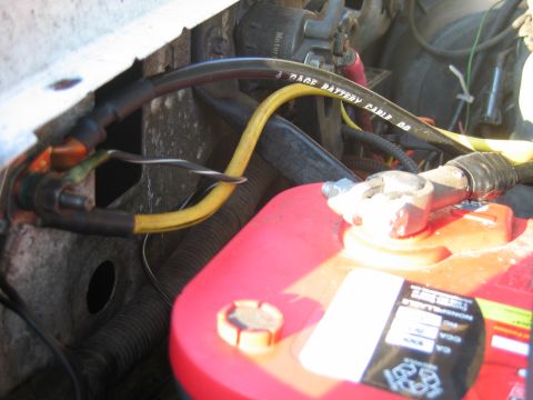 1992 Ford Bronco - Close-up of a vehicle battery and its associated wiring, including a cable labeled 'PAGE BATTERY CABLE'.