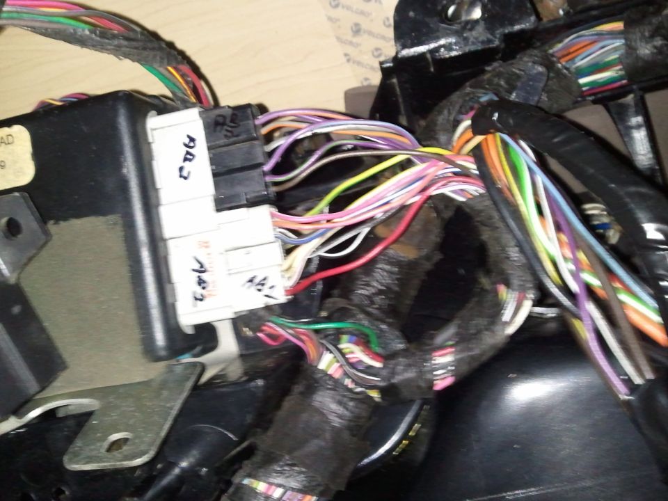 Close-up of a vehicle's complex wiring harness with labeled connectors