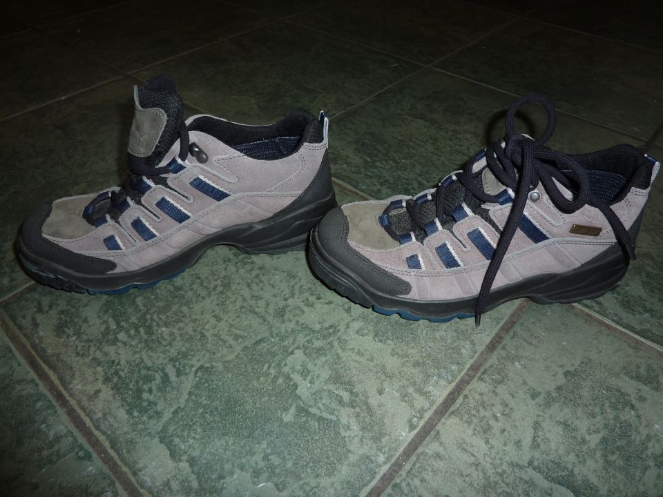 pair of gray and blue hiking boots on a tiled floor