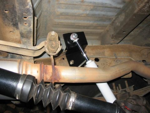 1995 Ford Bronco - Close-up view of the undercarriage, focusing on the shock absorber and exhaust system components.