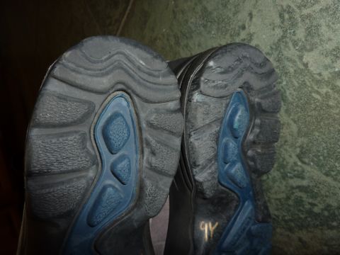 1900 Yugo GVX - Close-up view of the soles of two shoes, showing their tread and blue cushioning elements.