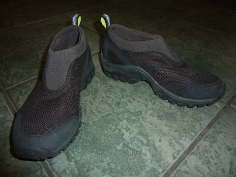 1900 Yugo GVX - A pair of black slip-on athletic shoes with mesh uppers and rubber soles are displayed on a tiled floor. The website "SUPERMOTORS.NET" is v…