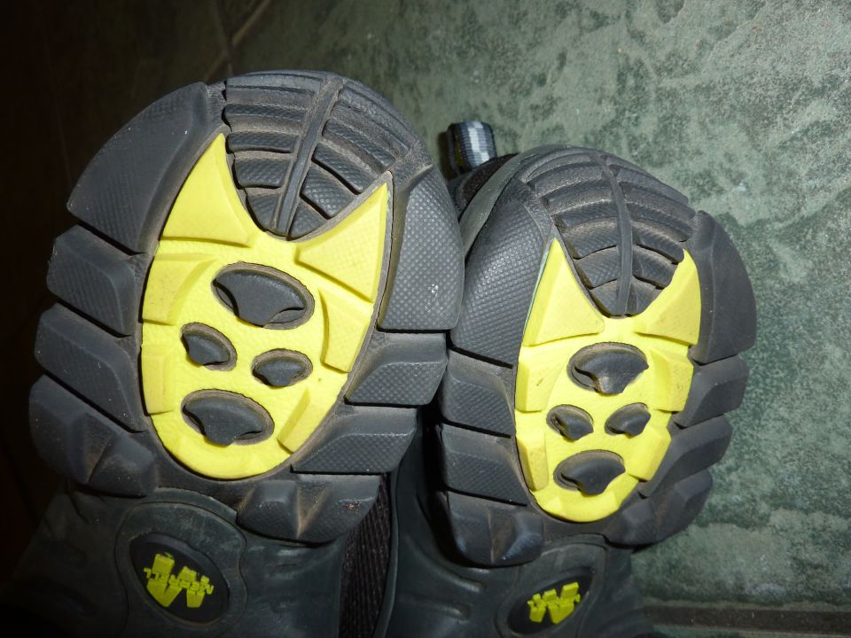 Black and yellow hiking boot soles with aggressive tread pattern