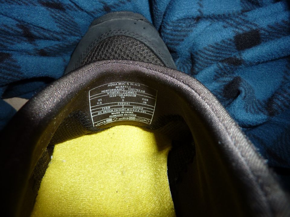 Interior of a black shoe showing a size label with Merrell branding