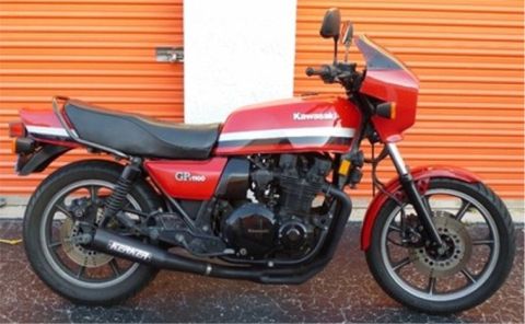 2008 Ford Crown Victoria - A red Kawasaki GP1100 motorcycle is parked in front of an orange garage door.